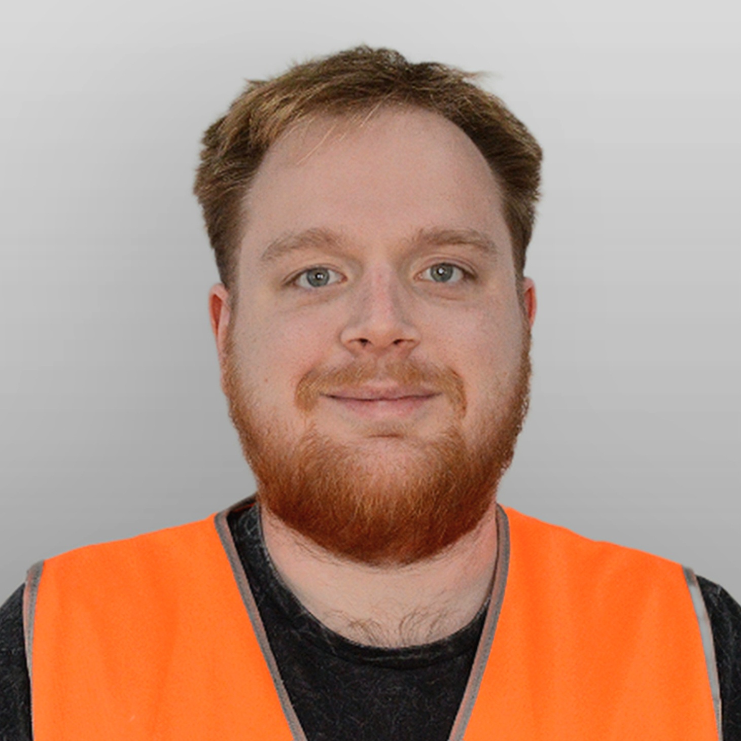 Edward smiles for the photo, wearing orange hi-vis and a dark t-shirt,