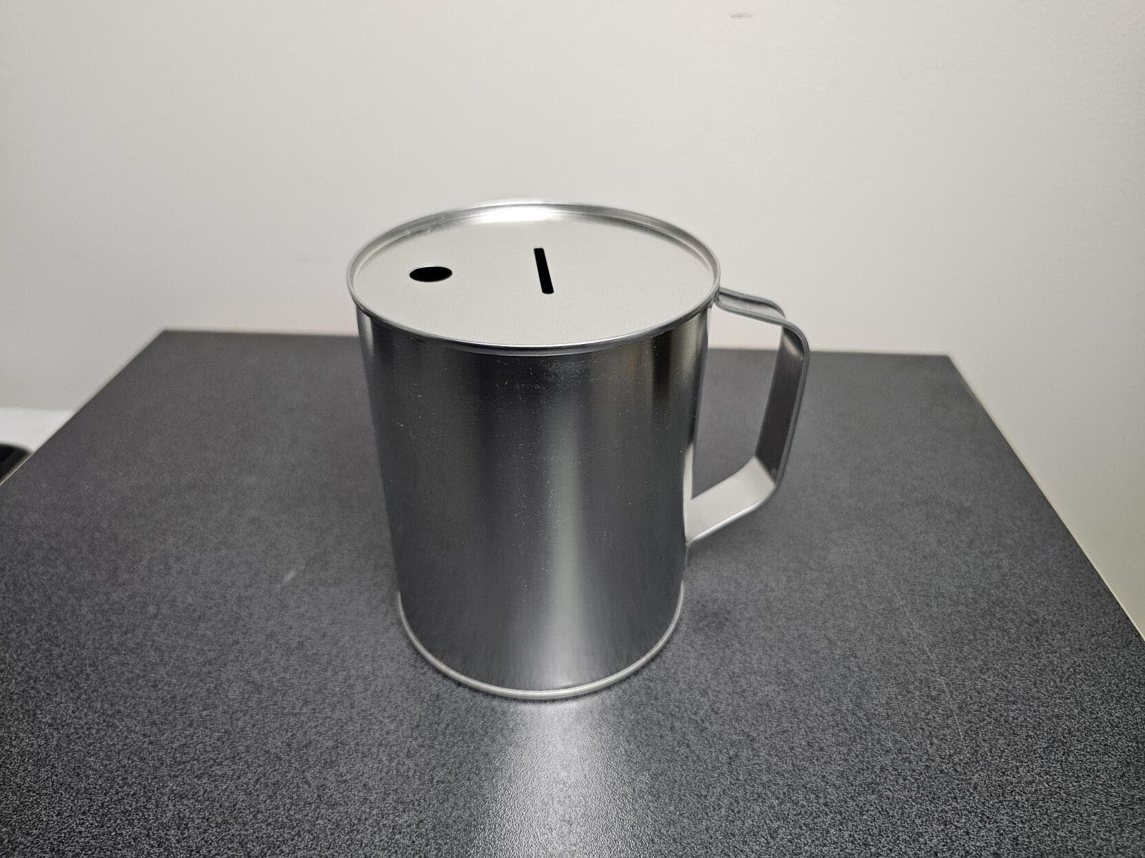 An unlabled fundraing collection tin sitting on a table