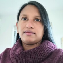 Raje poses for a photo; she has dark hair and is wearing a dark maroon sweater.