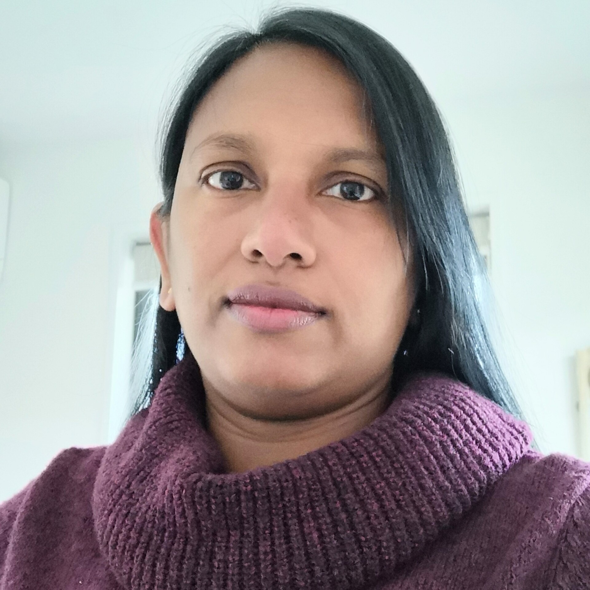 Raje poses for a photo; she has dark hair and is wearing a dark maroon sweater.